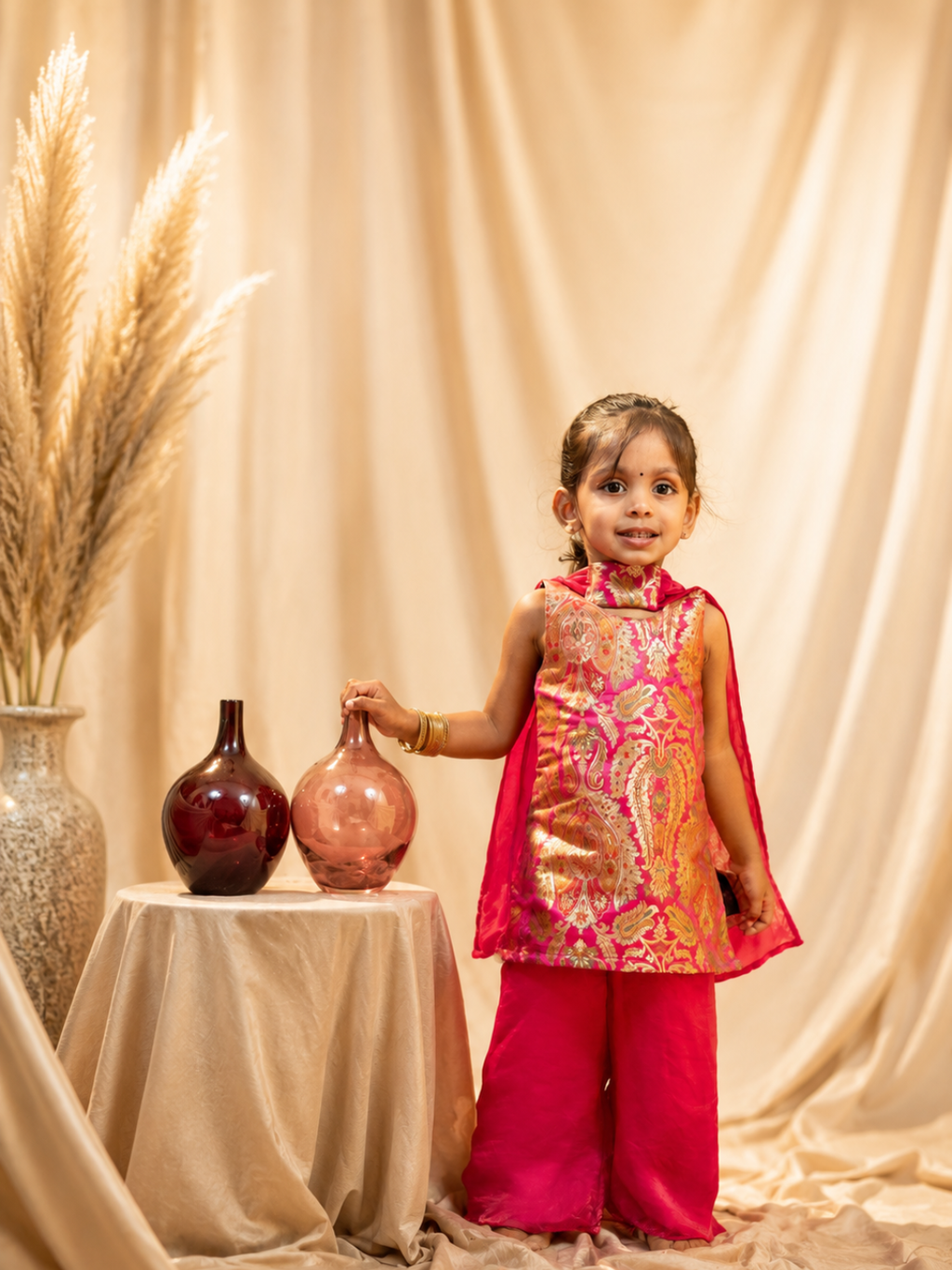 Front view of girl in Rani Pink Banarasi silk lehenga with paisley motifs – Pachikko festive Diwali kidswear